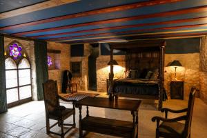 a bedroom with a bed and a table and chairs at Commanderie des Champs Forts in Saint-Aoustrille