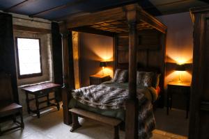 a bedroom with a canopy bed and two night stands at Commanderie des Champs Forts in Saint-Aoustrille