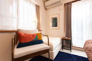 una camera da letto con un letto, una sedia e una finestra di 015T Y's INN 有客 瑞江 瑞江駅まで徒歩6分新宿まで乗換なし36分 3階建貸切 大人数向け ドンキそば a Tokyo