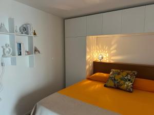 a bedroom with a bed with an orange pillow on it at Casa Venezia San Nicola in Bari