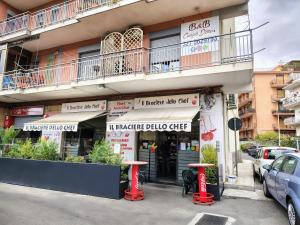 un ristorante con sgabelli rossi di fronte a un edificio di B&B Carpe Diem a Gravina di Catania