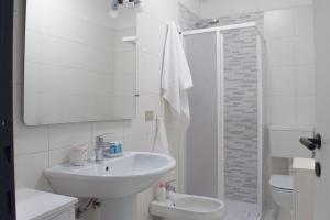 a white bathroom with a sink and a shower at Casa Gialla Soggiorno Panorama in Centro Storico in Dogliani