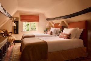 a bedroom with two beds and a window at The Merry Harriers Pub in Hambledon