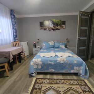 a bedroom with a bed with a blue comforter at Kovács Guesthouse in Praid