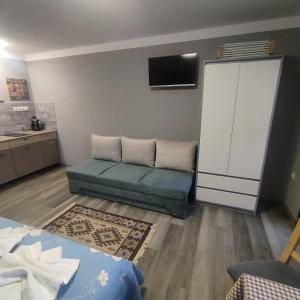 a living room with a couch and a tv at Kovács Guesthouse in Praid