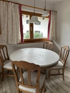 a table and chairs in a room with a window at Haus Berger in Bayrischzell