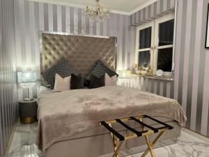 a bedroom with a large bed and a chandelier at Classico Uno in Meckenbeuren