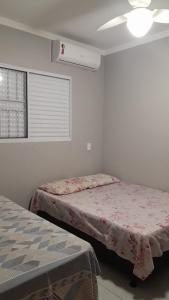 a bedroom with two beds and a window at KITNET PROX AO CENTRO - AR COND, WI-FI e ESTACIONAMENTO GRATIS in Maringá