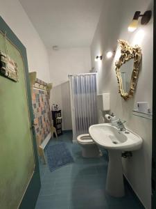 a bathroom with a sink and a toilet and a mirror at Affittacamere La Casa di Alma in Roncobillaccio +49 photos