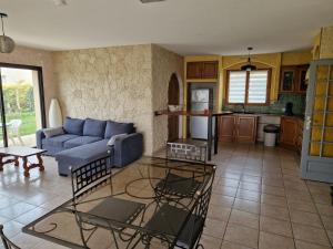 a living room with a blue couch and a table at Chambre d'hôtes in Saint-Martial-de-Valette