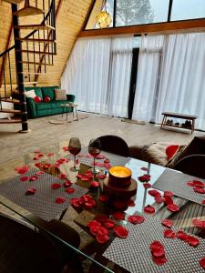 a table with wine glasses and roses on it at Codrii Doftanei in Teşila