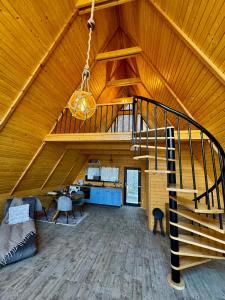 an attic room with a staircase in a wooden ceiling at Codrii Doftanei in Teşila