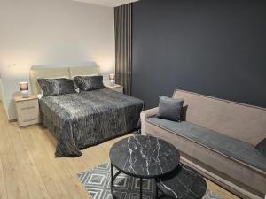 a bedroom with a bed and a couch and a table at Residence Riverside in Mostar