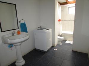 La salle de bains est pourvue d'un lavabo, de toilettes et d'un miroir. dans l'établissement LA CABAÑA IDEAL PARA FAMILIAS DE 6 a 12 PERSONAS!, à Hanga Roa