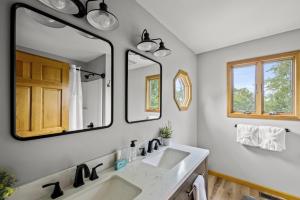 un bagno con due lavandini e due specchi di High Top Cabin in the Smokies a Sevierville Altre 148 foto