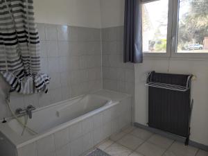 Un baño con bañera y ventana. en Appartement dans haras, en Saint-André-le-Puy