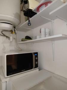 a kitchen with a microwave and some shelves at Centre ville Bagnols sur Cèze in Bagnols-sur-Cèze