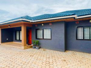a blue house with a red door at Jacobi Apartments in Kitwe