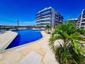 a swimming pool in front of a tall building at Arraial do Cabo. Conforto, Piscina, Vista Mar. in Arraial do Cabo