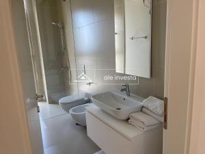 Un baño con lavabo, inodoro y espejo. en Green Coast 60 a, en Palasë