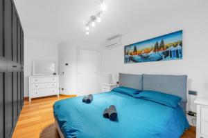 a bedroom with a blue bed and a painting on the wall at Milano-Rho Fiera Exclusive stay private parking in Rho