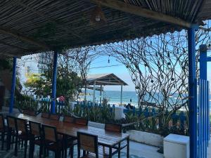 un ristorante con tavolo e sedie e la spiaggia di Phước Đồng Homestay - Cù Lao Mái Nhà a Tuy An