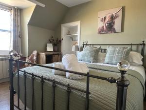 ein Schlafzimmer mit einem Bett mit einem Bild einer Kuh in der Unterkunft Knockenhooley Cottage in Breakish