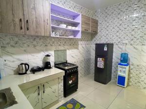 a kitchen with a stove and a refrigerator at Two Bedroom, City View Apartment, Bondeni, Mombasa in Mombasa +7 photos