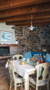 a dining room table with chairs and a stone wall at Casa Silvia II mit Seeblick mit Terrasse in Torri del Benaco