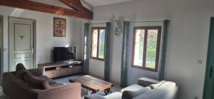 a living room with two couches and a table at Mas de Guinot in Villeneuve