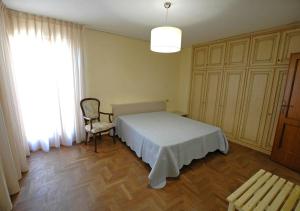 Un dormitorio con una cama y una silla y una ventana. en Villa Dei Golfi, en Capoliveri