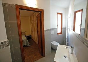 Un baño con lavabo, inodoro y espejo. en Villa Dei Golfi, en Capoliveri 9 fotos más