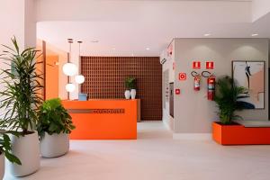 an office with potted plants and an orange counter at Lille Cambui Studios Luxo by Robert Stays in Campinas +131 photos