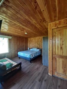 a bedroom with a bed and a wooden ceiling at Cabaña Vista Hermosa 6 Personas Conaripe in Panguipulli