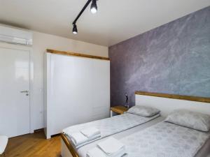 a bedroom with two beds and a gray wall at Luxury apartment in building K55 with free garage in Varna City