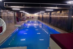a large swimming pool with blue water in a building at Uve Residence & Spa in Piatra Neamţ