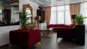 a living room with two red couches and a mirror at Uve Residence & Spa in Piatra Neamţ