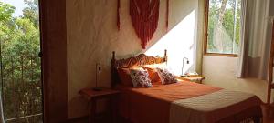 une chambre avec un lit et une grande fenêtre dans l'établissement Villa do Sol, à Conceição da Ibitipoca