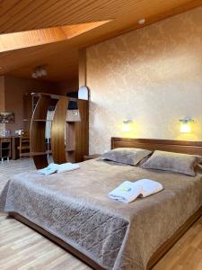 a bedroom with a large bed with towels on it at Готель ПАРК in Morshin +51 photos