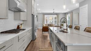 a kitchen with white countertops and a living room at Queen Palm in Inlet Beach