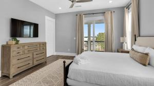 a bedroom with a bed and a dresser with a television at Queen Palm in Inlet Beach +87 photos