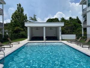 a swimming pool with chairs and a pavilion at Queen Palm in Inlet Beach