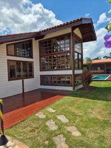 a house with a wooden deck and a yard at Casa Raízes - Atibaia in Atibaia