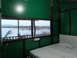 een kamer met een bed en uitzicht op een rivier bij yala treetop lake in Tissamaharama