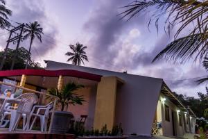 a house with chairs sitting outside of it at Flat Vila dos Milagres in São Miguel dos Milagres