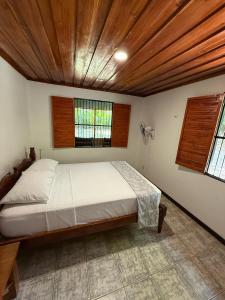 a bedroom with a large bed with a wooden ceiling at Hacienda Baru in Dominical +56 photos