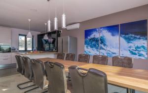 ein Esszimmer mit einem langen Tisch und Stühlen in der Unterkunft Villa Eligo mit 2 Whirlpools, Meerblick, Pool und Fitnessraum in Premantura