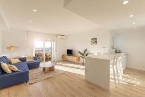 a living room with a blue couch and a kitchen at Baleal Blue Sky in Ferrel