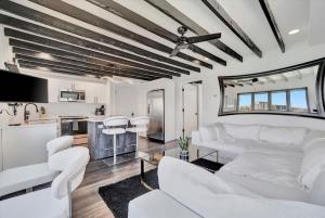 a living room with white furniture and a kitchen at The Aura a Luxury Waterview Condo & heated pool in Clearwater Beach +15 photos