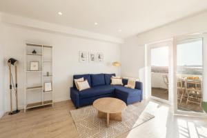 a living room with a blue couch and a table at Baleal Blue Sky in Ferrel